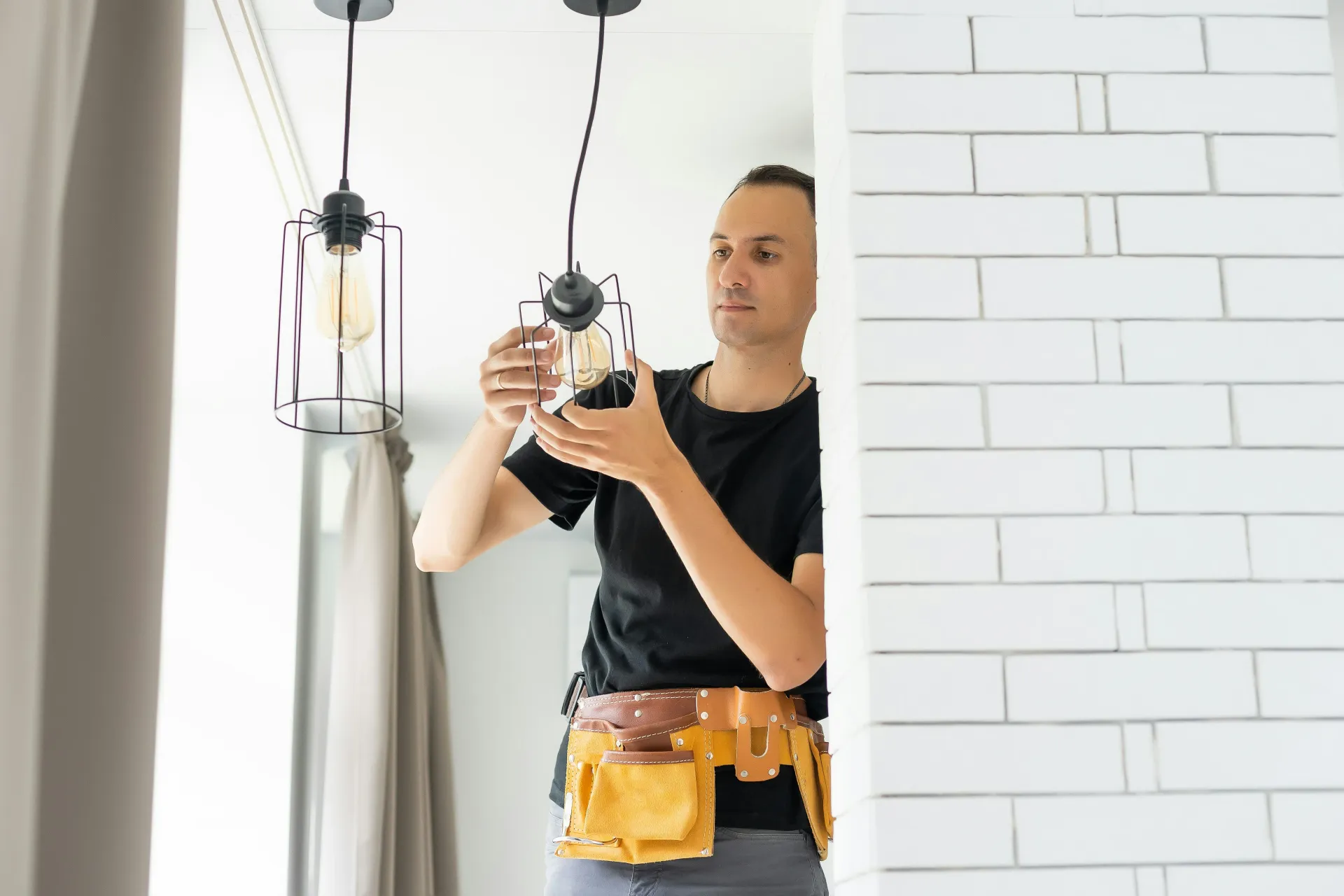 Electrician installing a modern pendant light fixture
