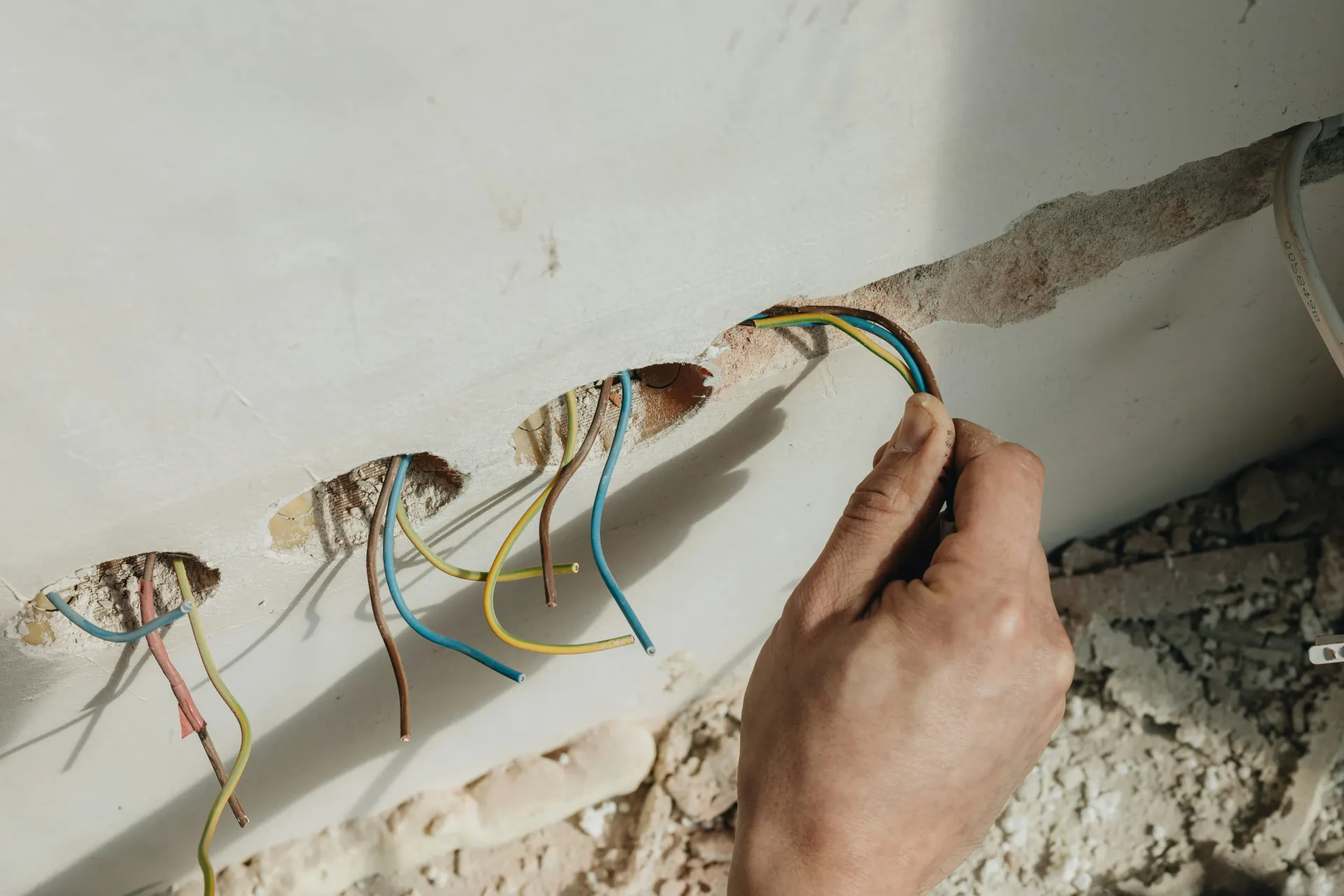 Electrician working on electrical wiring during a house rewire or renovation.